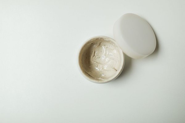 Close-up of an opened jar of moisturising cream showing the smooth cream inside.